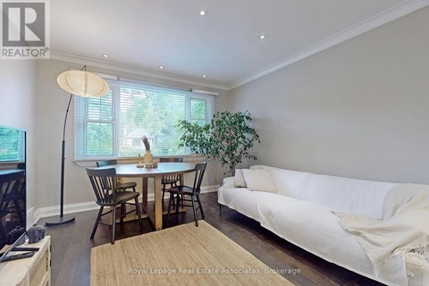 A well-lit living room with a dining table and chairs.