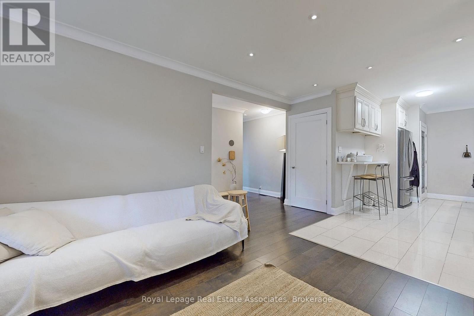 A white couch is in the middle of a spacious room.