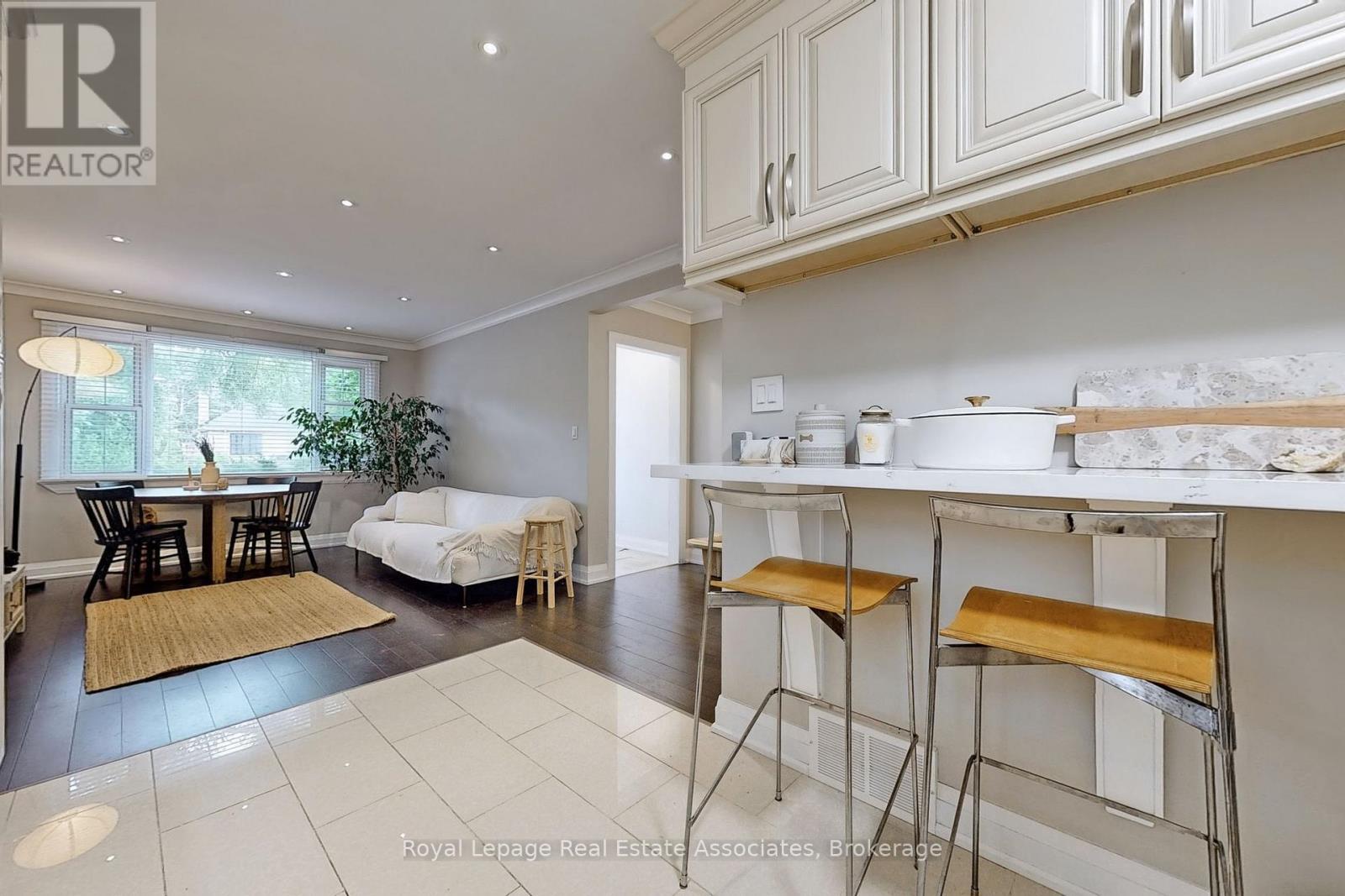 A well-lit kitchen with white cabinets and a breakfast bar.