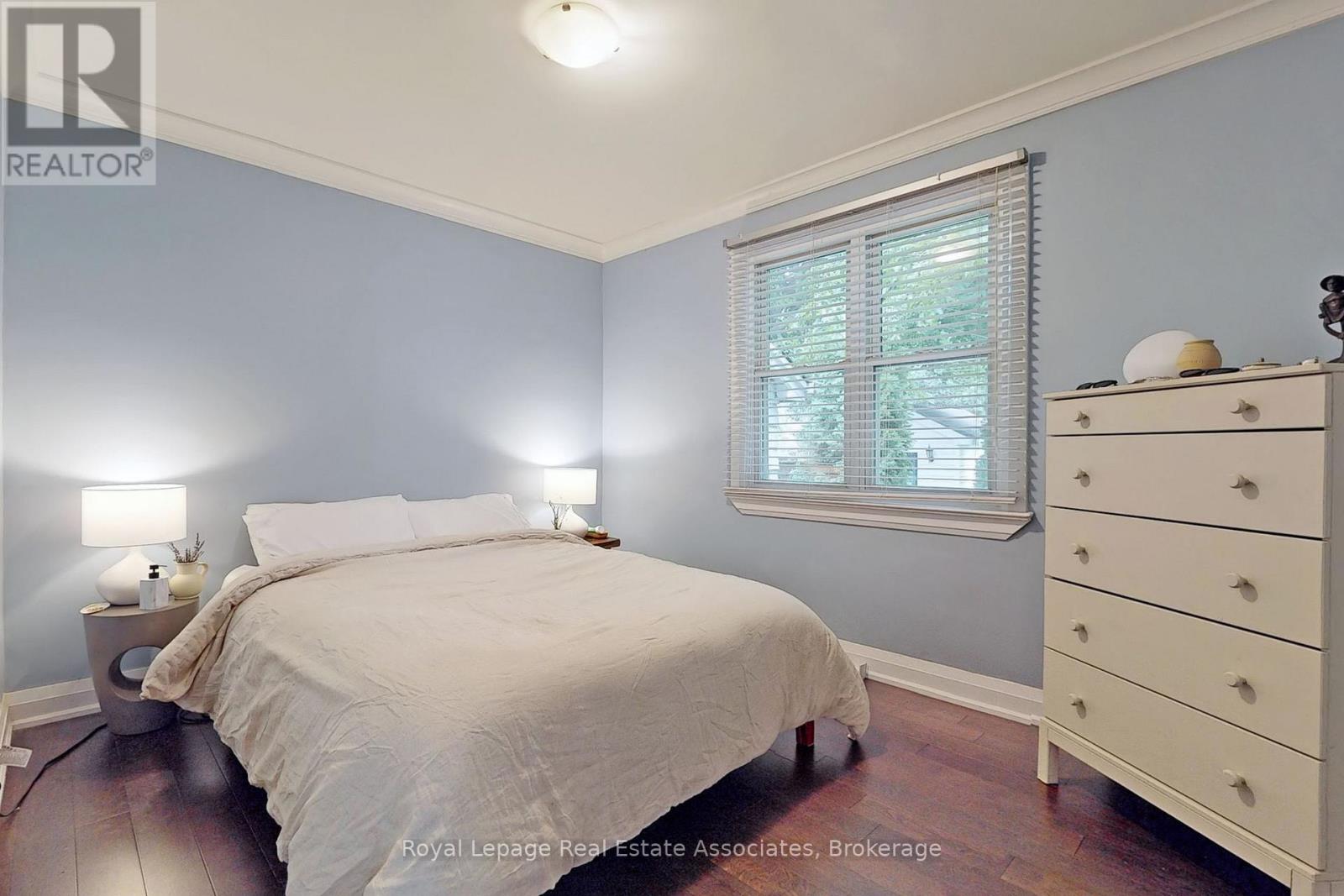 A bedroom with a bed, nightstand, and dresser.