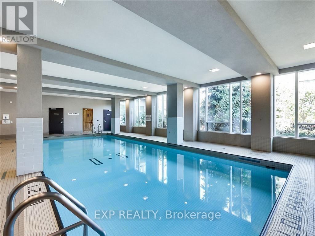A large indoor swimming pool with a tiled edge and a metal hand rail.