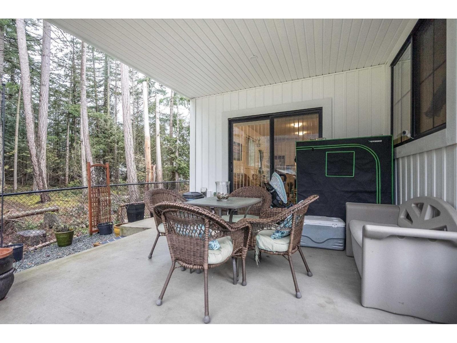 A patio with a table and chairs and a hot tub.