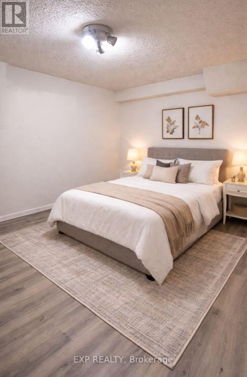 A bedroom with a bed, nightstand, and two wall lamps.