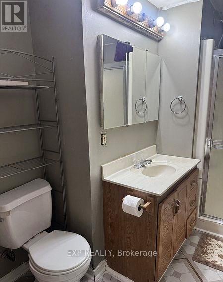 A white toilet sits next to a sink in a small bathroom.