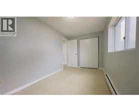 A white bedroom with a large closet and a window.