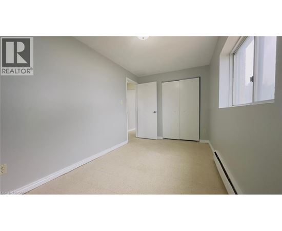 A white bedroom with a large closet and a window.
