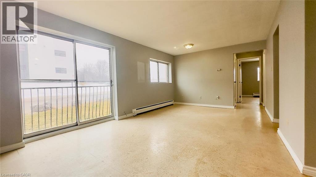 A spacious room with a sliding glass door leading to a balcony.