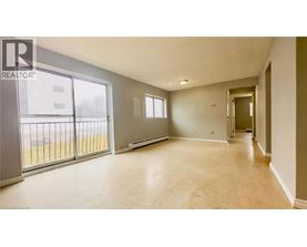 A spacious room with a sliding glass door leading to a balcony.