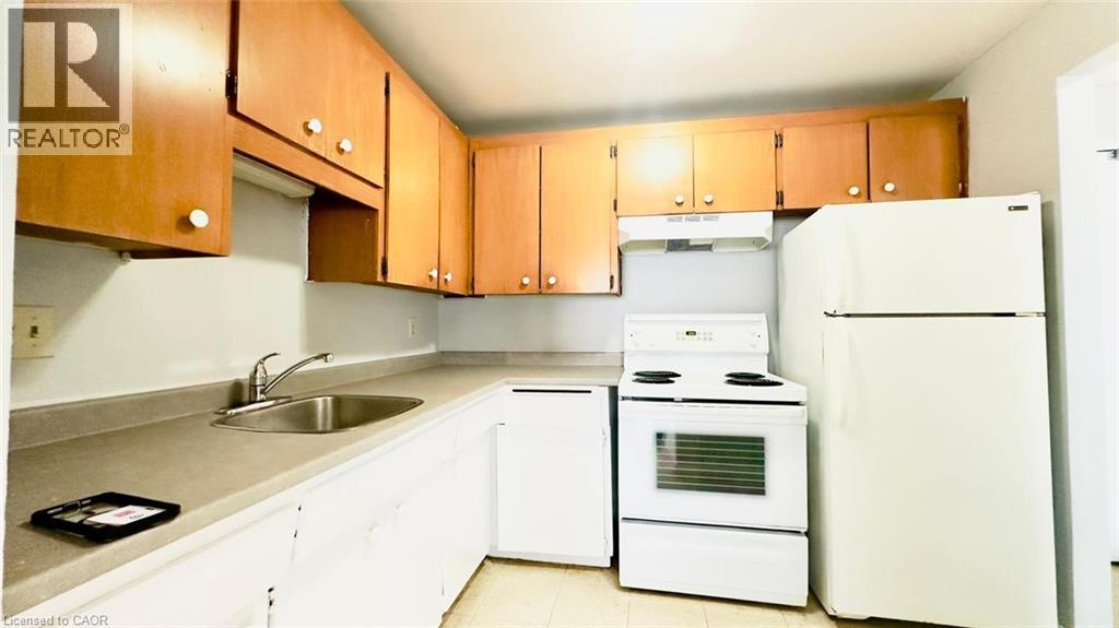 A kitchen with white appliances and wooden cabinets.
