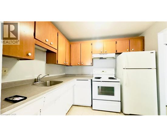 A kitchen with white appliances and wooden cabinets.