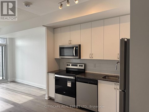 A kitchen with white cabinets and black appliances.