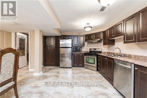 A kitchen with dark wood cabinets and stainless steel appliances.