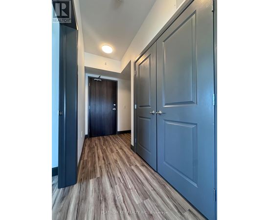 A hallway with wood flooring and blue doors.