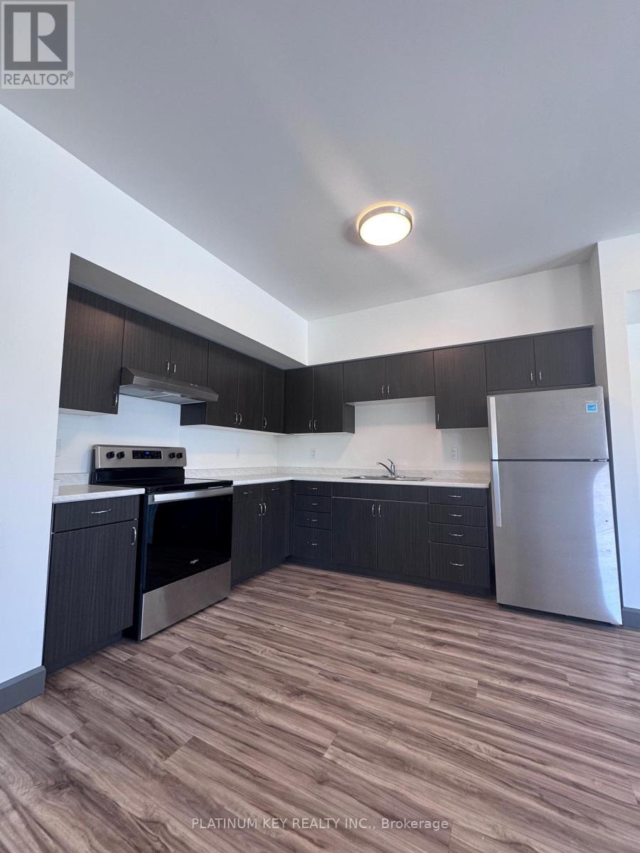 A kitchen with dark wood cabinets and stainless steel appliances.