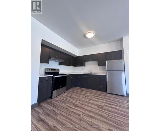 A kitchen with dark wood cabinets and stainless steel appliances.