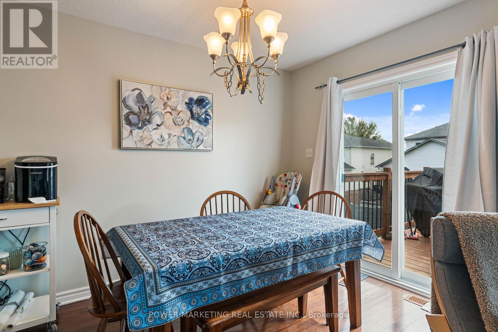 A dining room with a blue tablecloth and a chandelier.
