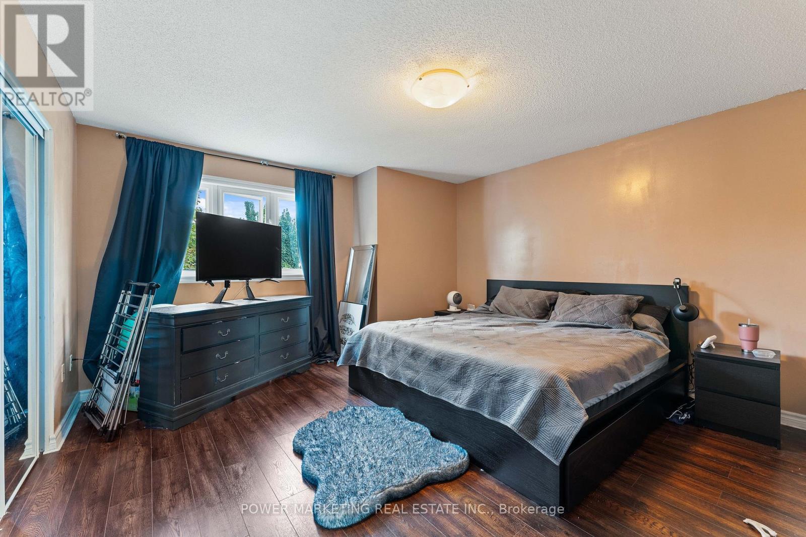 A bedroom with a large bed and a television in the corner.