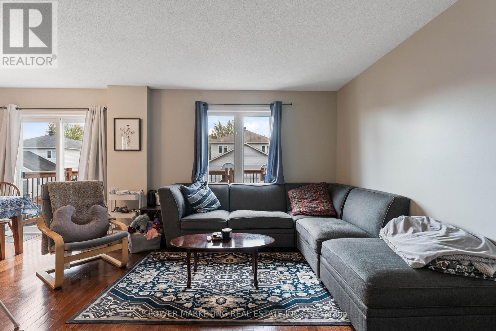 A living room with a grey couch and a wooden chair.