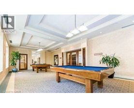 A room with a pool table and a plant.