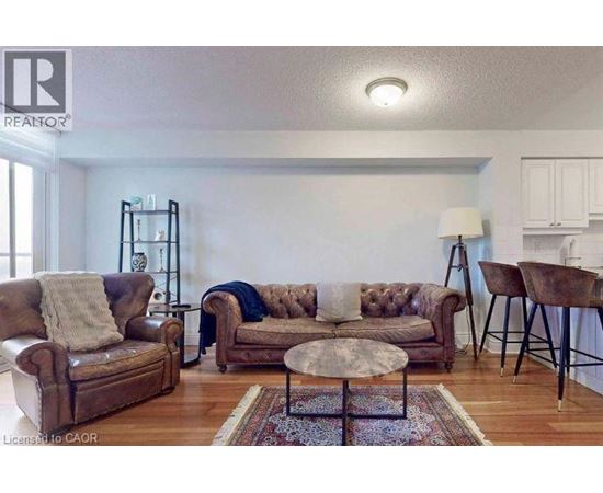 A living room with a brown leather couch and a round table.