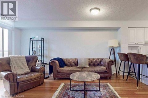 A living room with a brown leather couch and a round table.