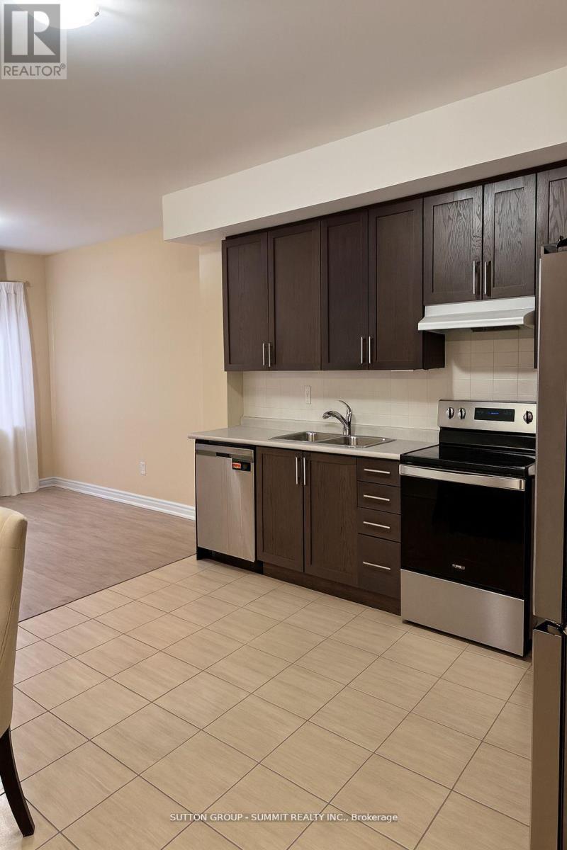 A kitchen with brown cabinets and stainless steel appliances.