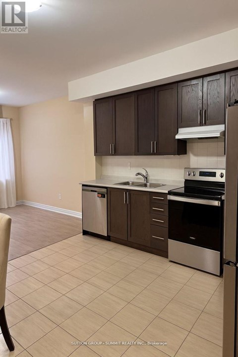A kitchen with brown cabinets and stainless steel appliances.