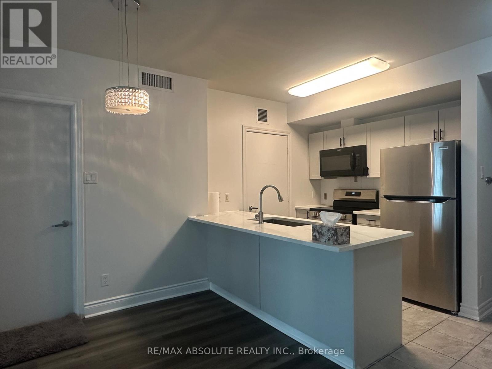 A kitchen with a sink, stove, and refrigerator.
