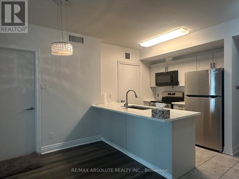 A kitchen with a sink, stove, and refrigerator.
