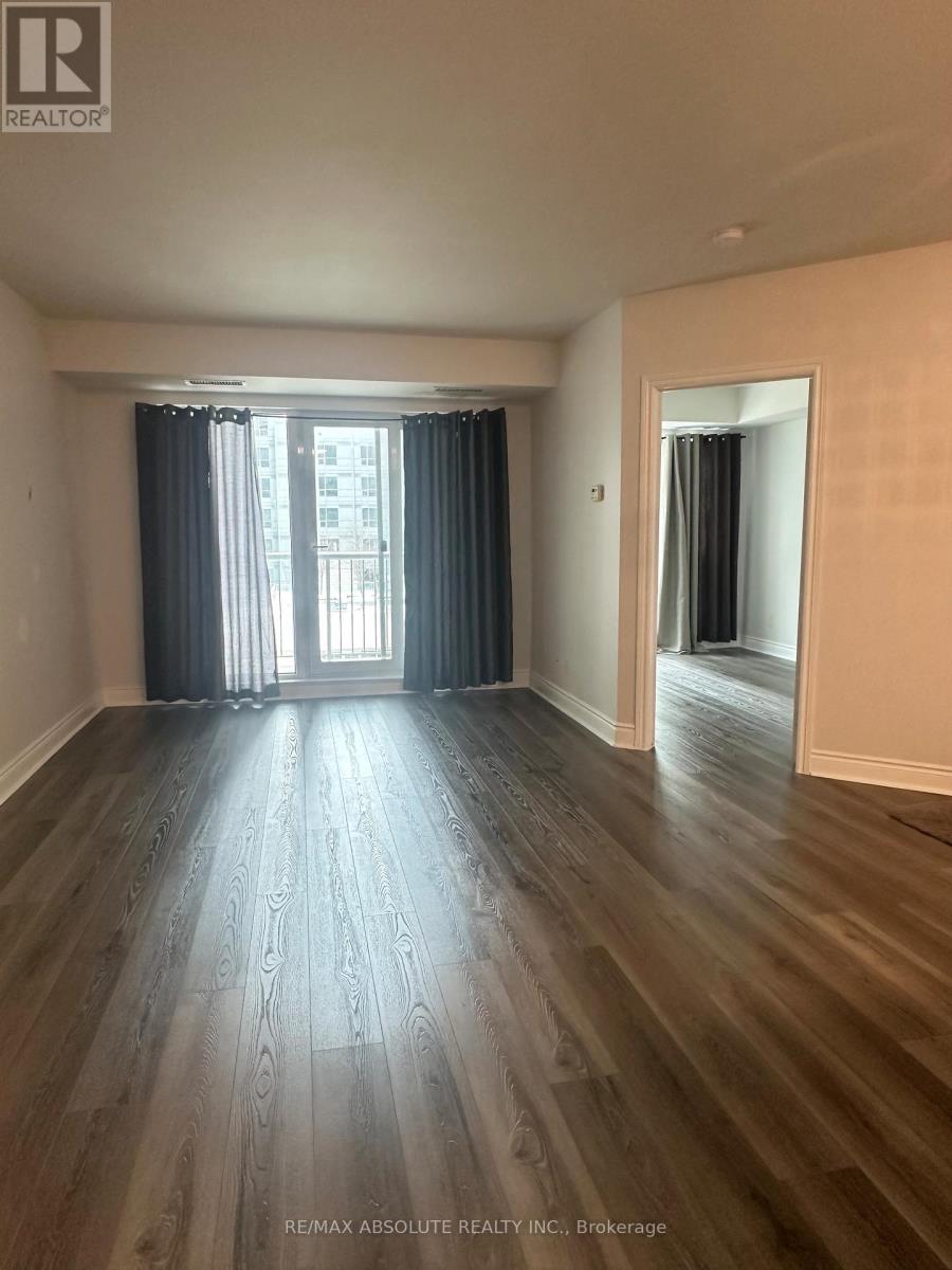 A room with wooden flooring and a window with curtains.