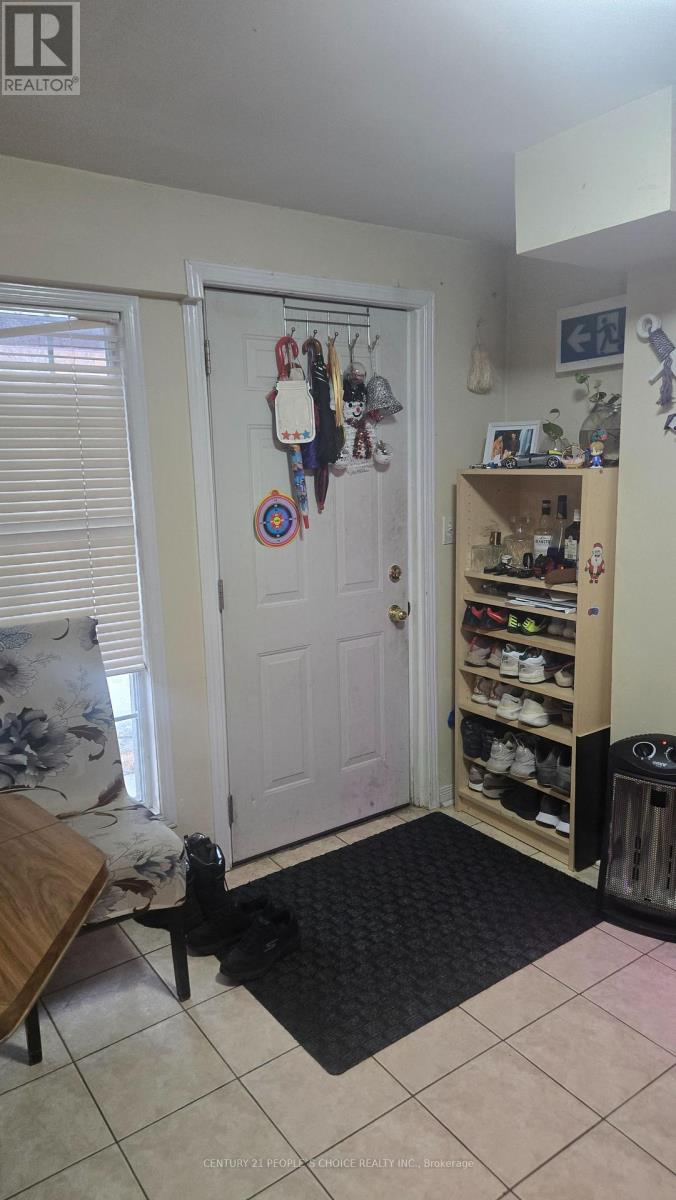 A room with a door, a shoe rack and a mat on the floor.