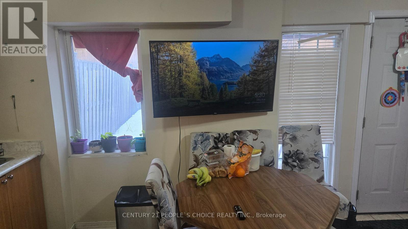 A living room with a flat screen TV mounted on the wall.