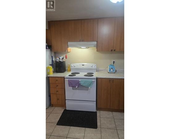 A kitchen with a white stove and wooden cabinets.