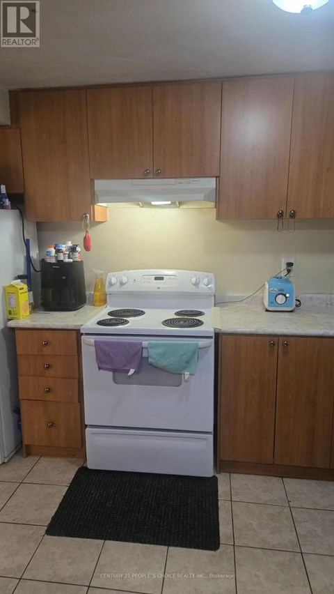 A kitchen with a white stove and wooden cabinets.