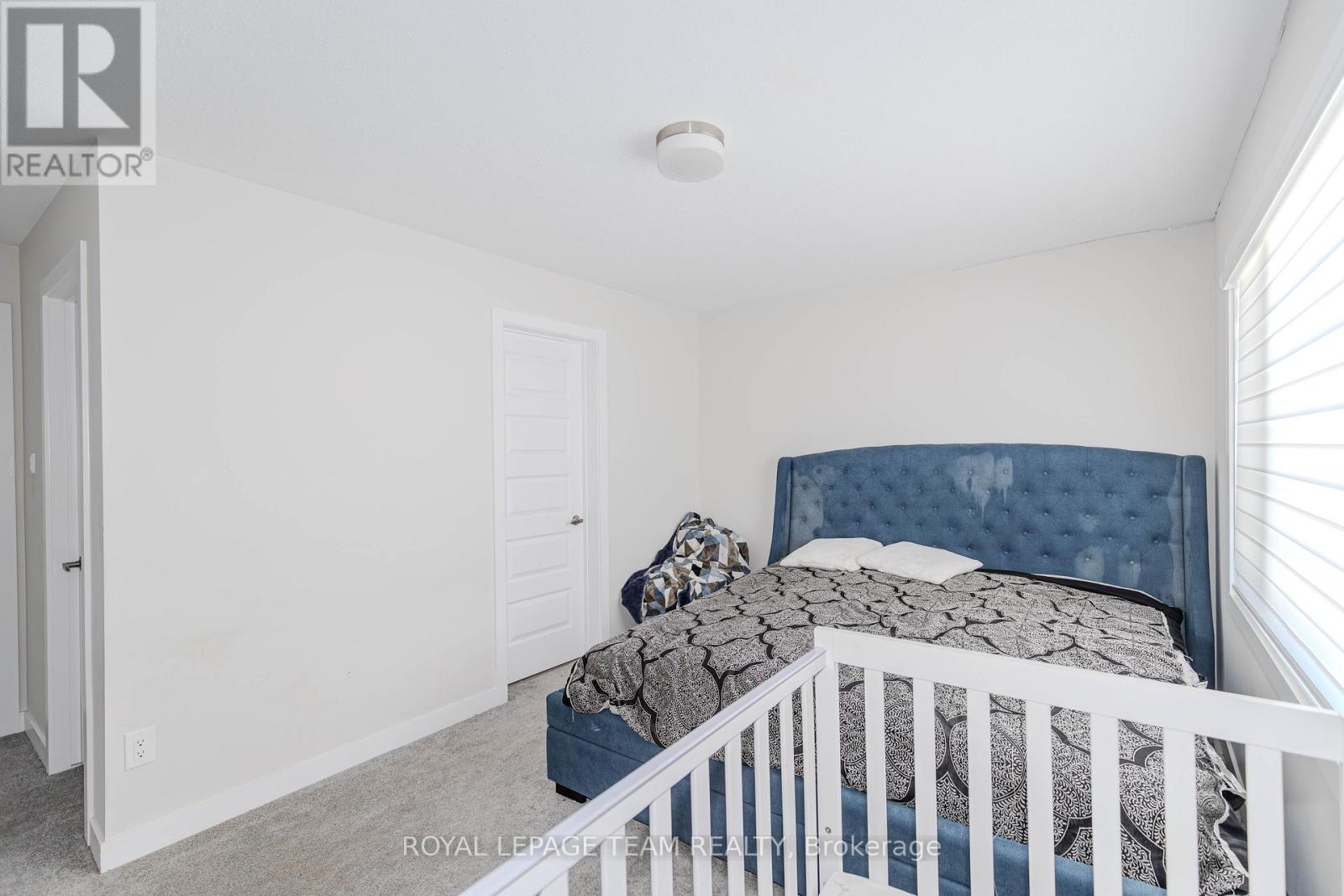 A bedroom with a white bed and a blue headboard.