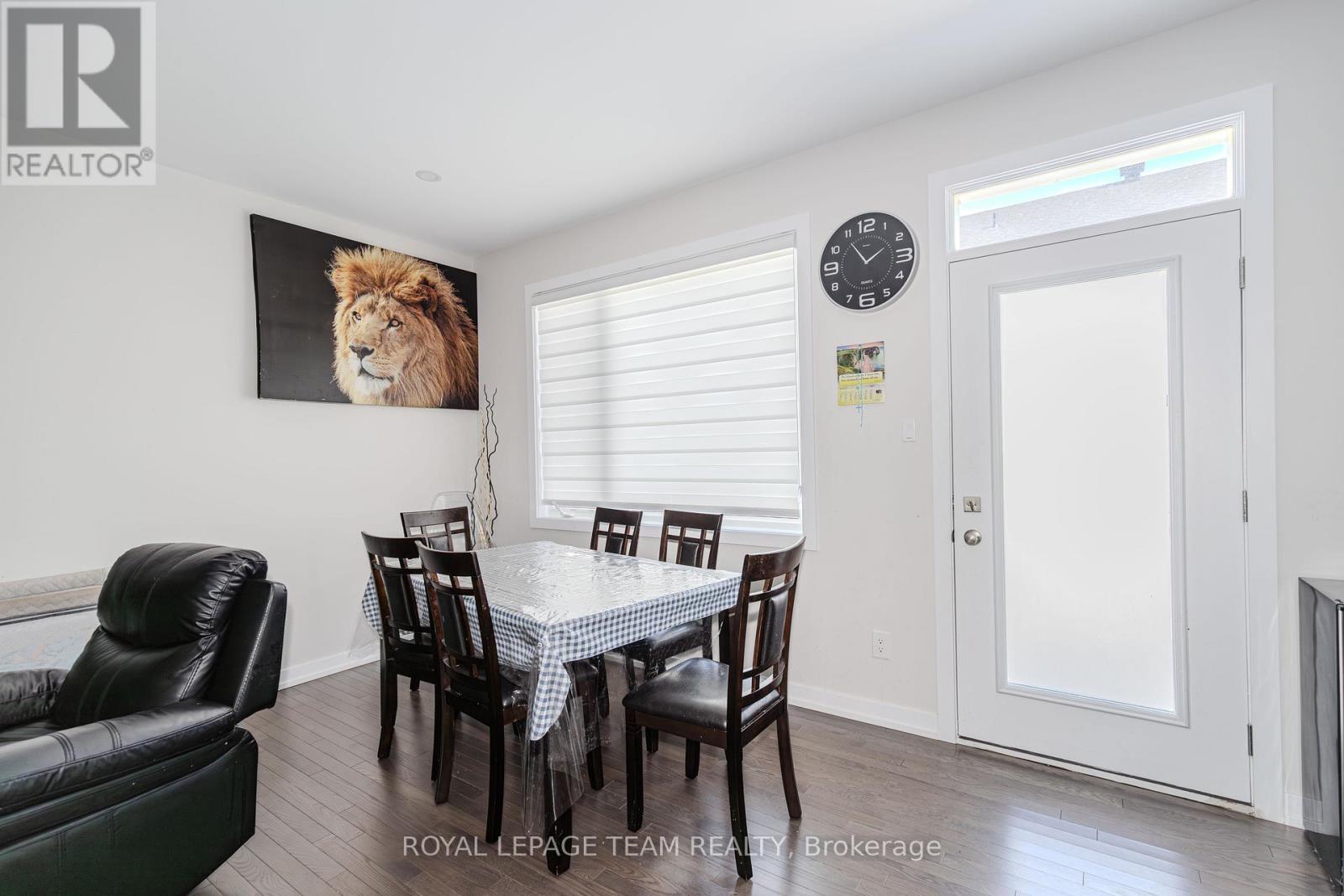 A dining room with a table set for four and a lion poster on the wall.