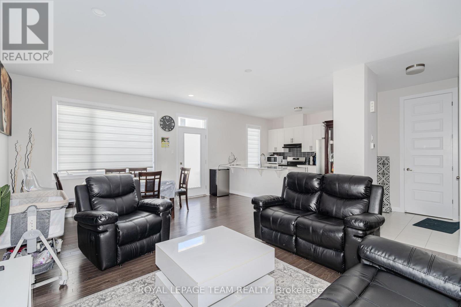 A living room with black leather furniture and a white coffee table.