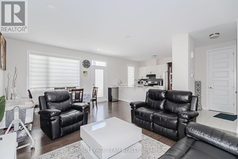 A living room with black leather furniture and a white coffee table.