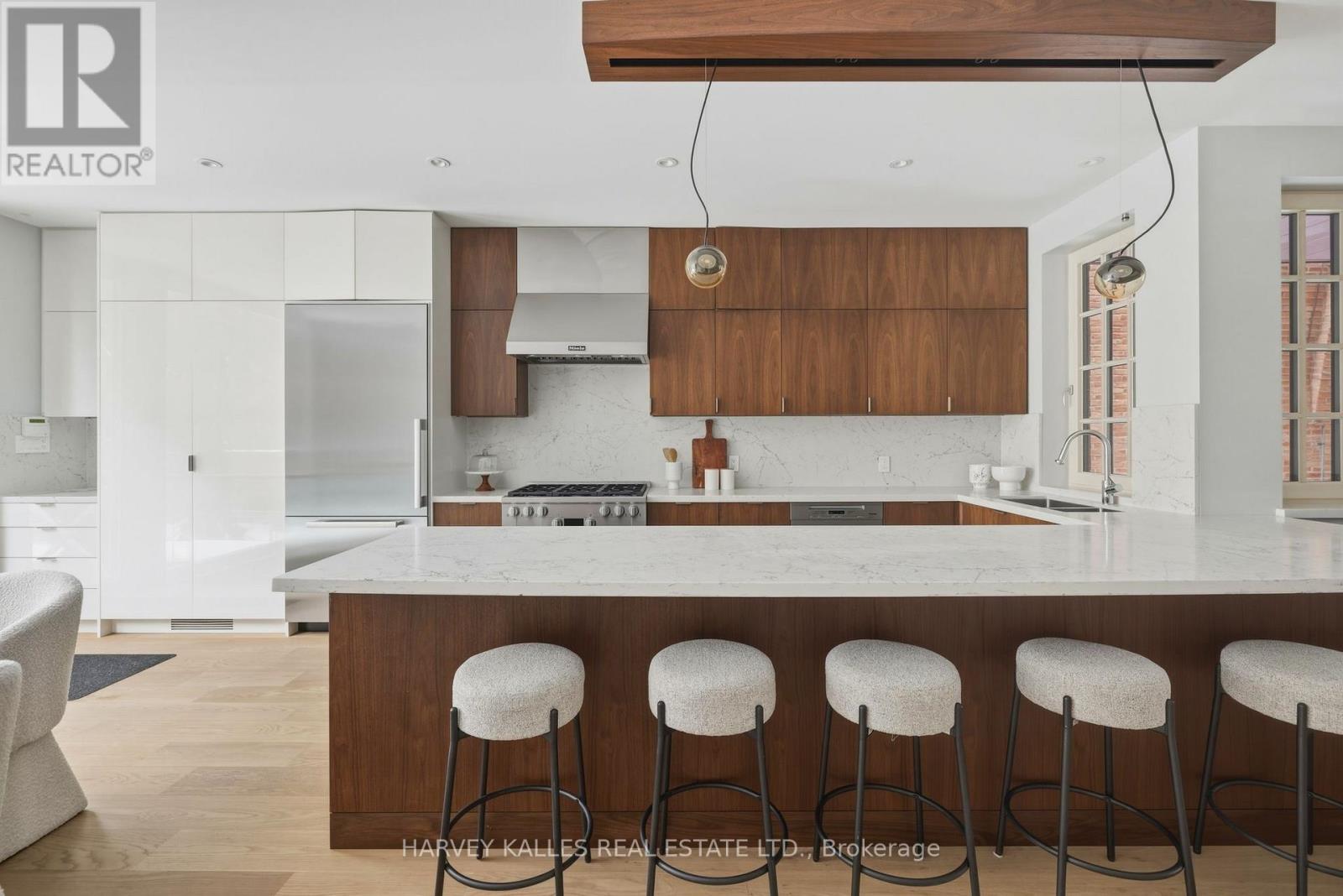 A modern kitchen with white cabinets and a wooden island.