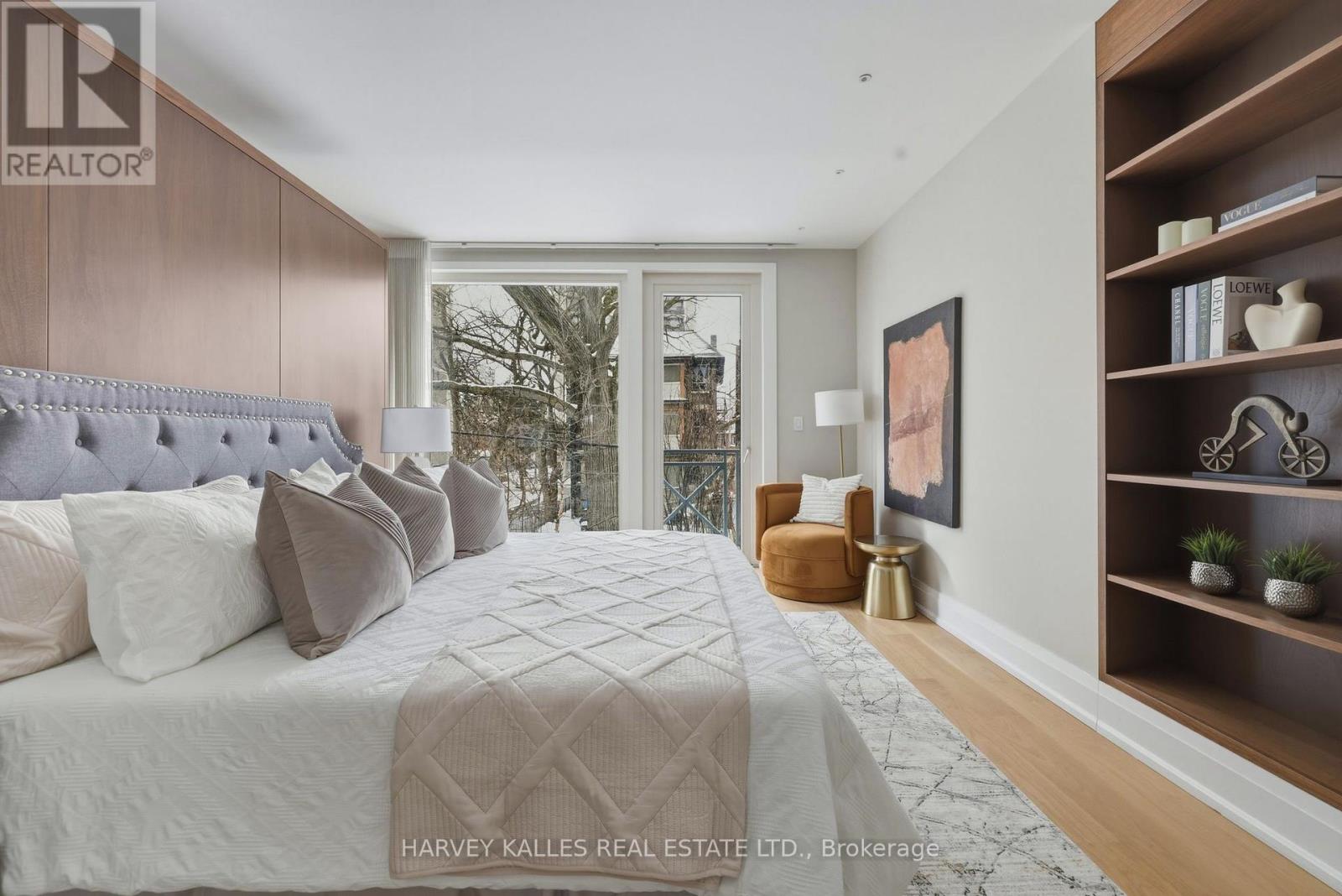 A bedroom with a large bed and a window overlooking a cityscape.
