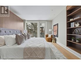 A bedroom with a large bed and a window overlooking a cityscape.