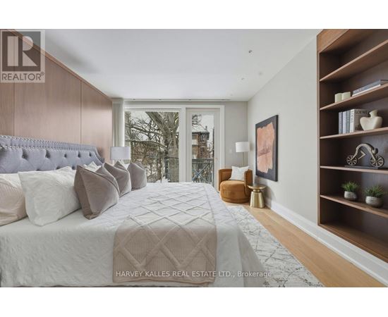 A bedroom with a large bed and a window overlooking a cityscape.