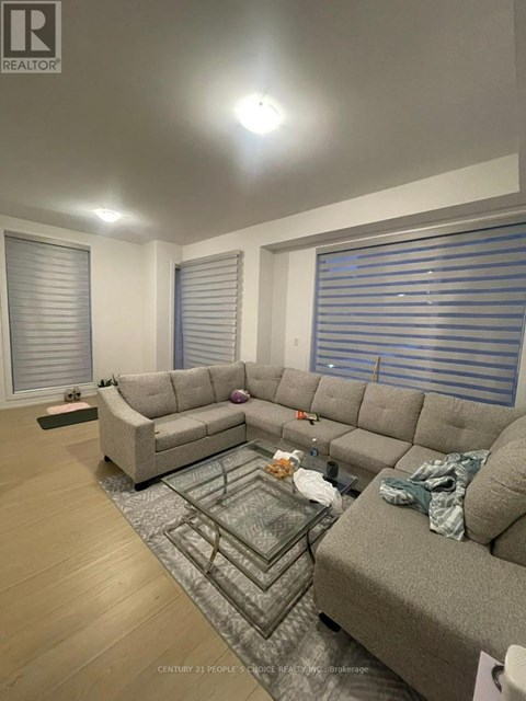A living room with a grey sofa and a glass coffee table.