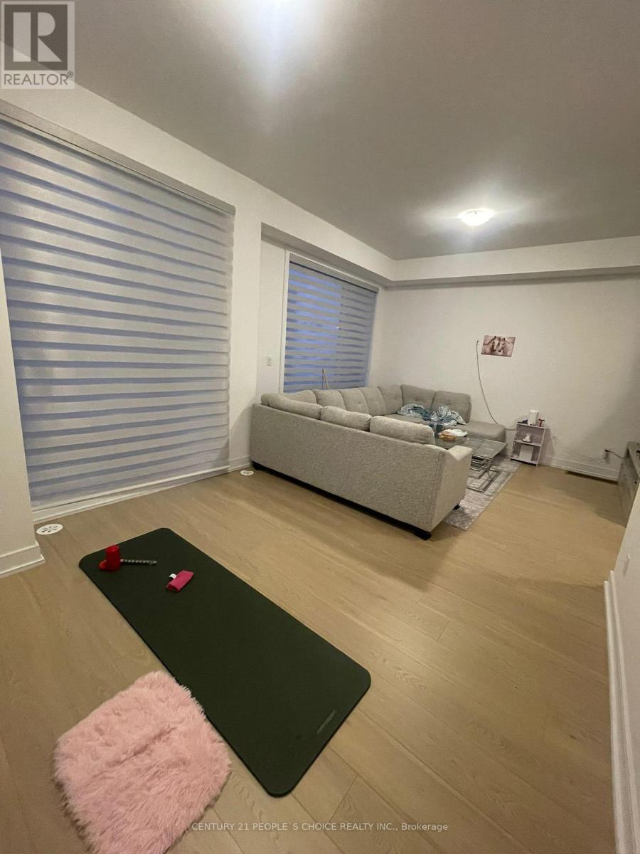 A yoga mat with a red heart on it is on the floor in a room with a grey sofa.