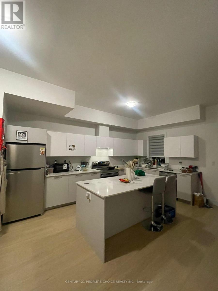 A kitchen with white cabinets and a stainless steel refrigerator.