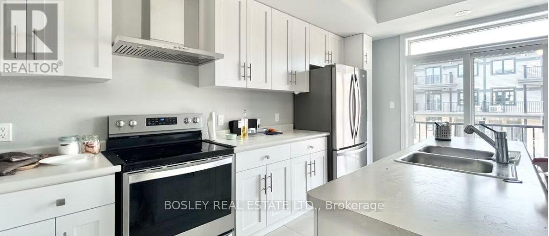A kitchen with a stove top oven, refrigerator, and sink.
