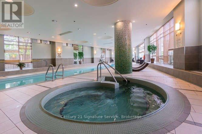 A large indoor swimming pool with a waterfall feature in the middle.