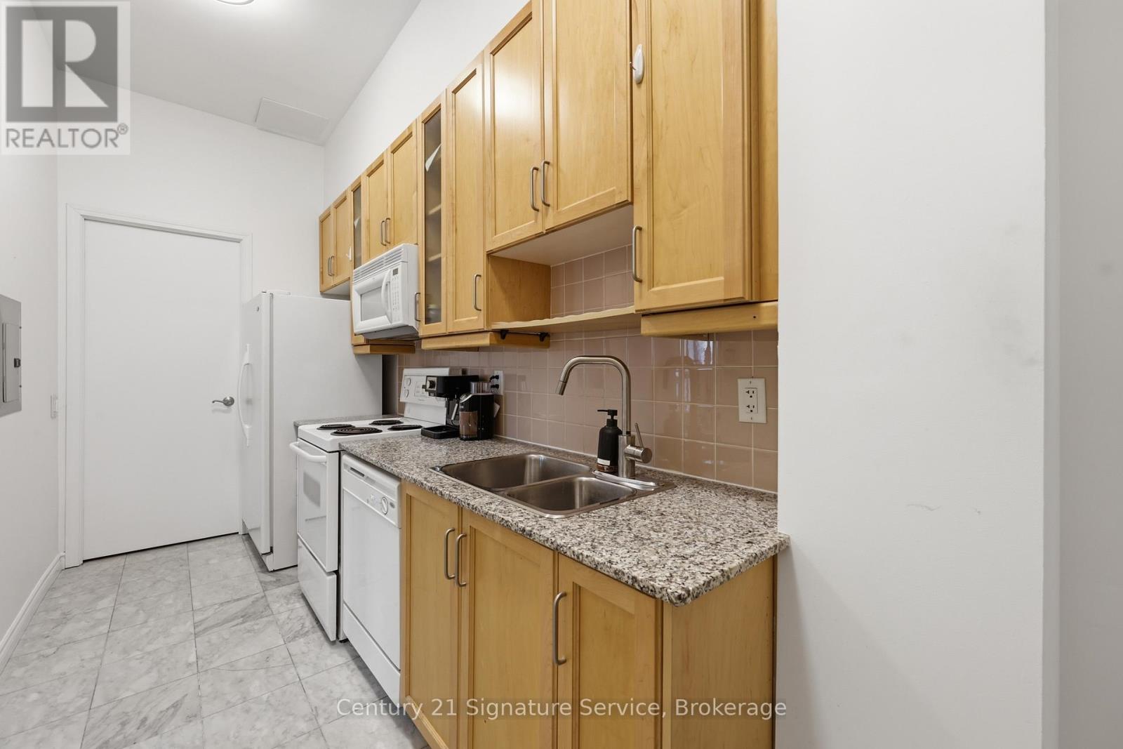 A kitchen with wooden cabinets and a granite countertop.