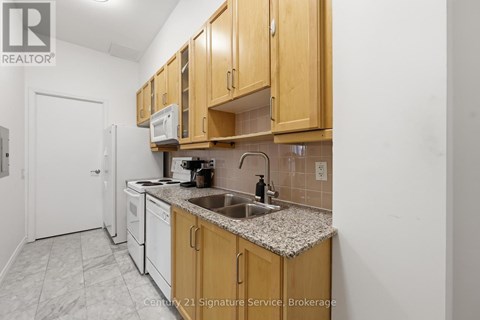 A kitchen with wooden cabinets and a granite countertop.