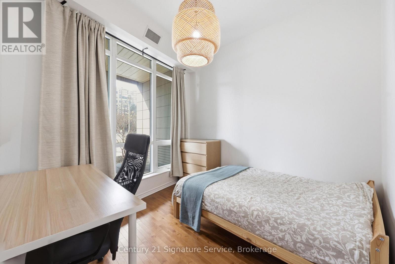 A bedroom with a bed, desk, and chair.